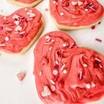 three finished Valentine's Day iced sugar cookies with wprinkles